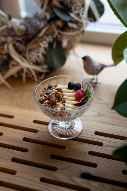 Granola s jogurtem, banánem a ovocem ve skleněné misce